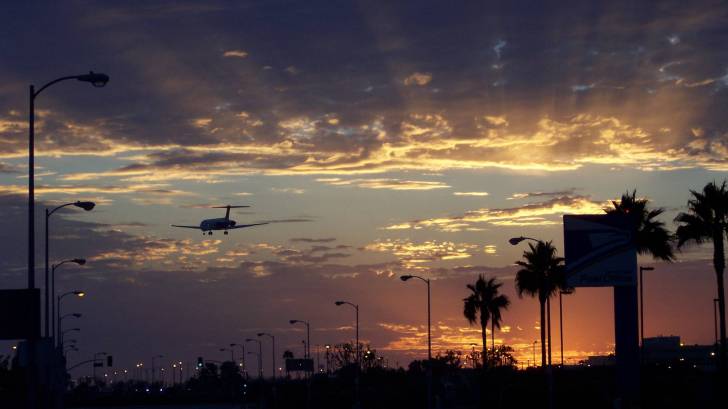 international jet landing at lax at sundown