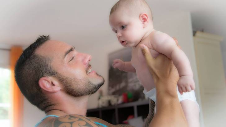 dad holding up young child