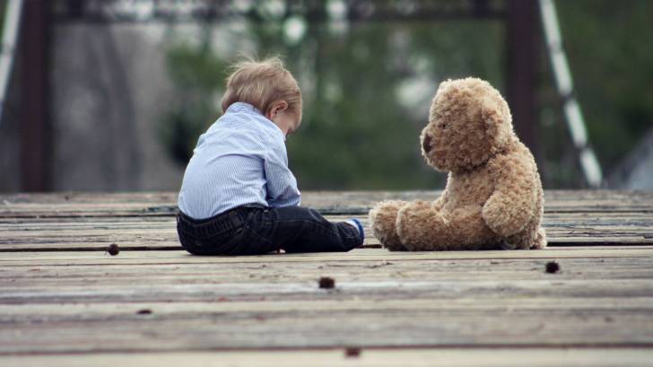 toddler with toy bear