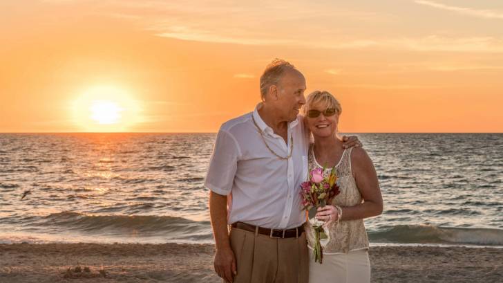 older couple on beach for wedding happy