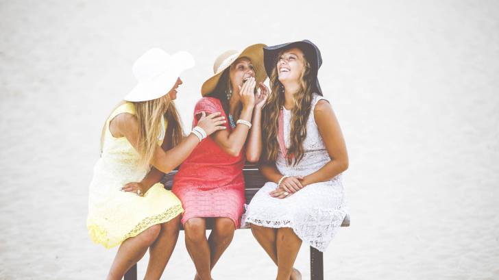 women sitting on a bench happy