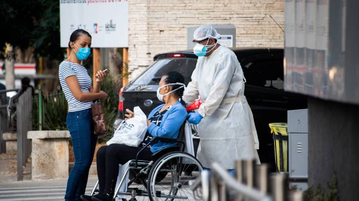 person being wheeled out of the hospital after recovering from COVID-19