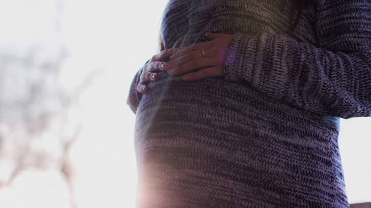 belly of a pregnant women with the sun shining on it