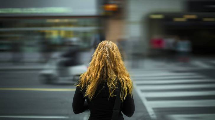 young girl trying to cross a busy city street