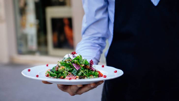 waiter serving a salad