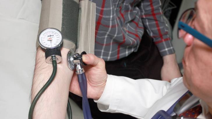 doctor taking blood pressure of a patient