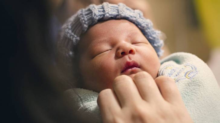 newborn being held by mom