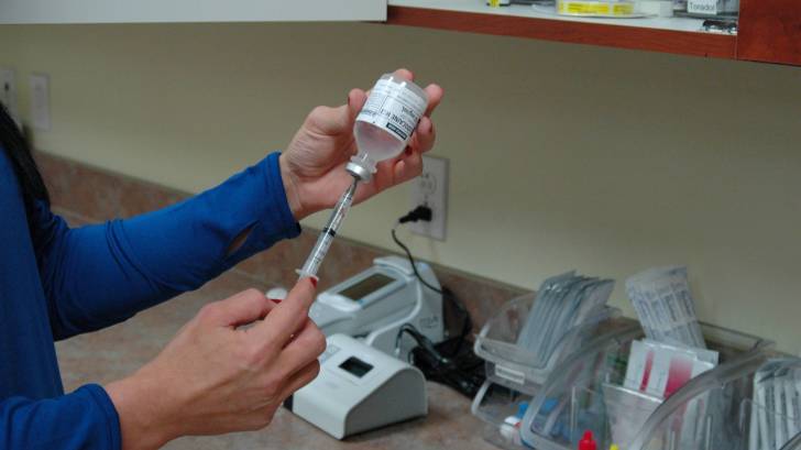 nurse filling a syringe to give a vaccination