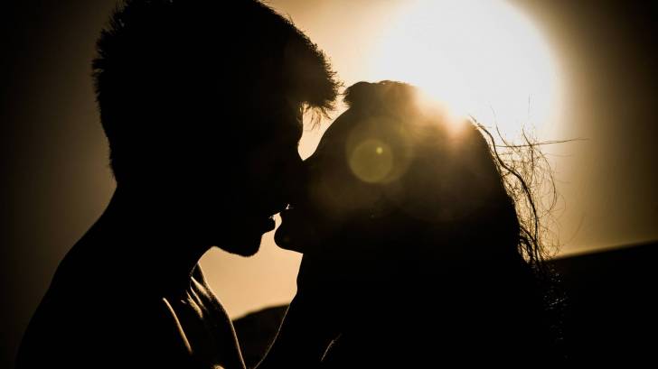 couple kissing at sunset