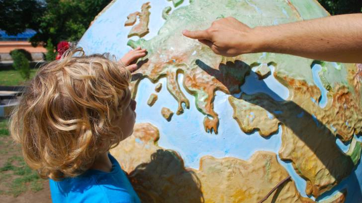 child looking at a globe