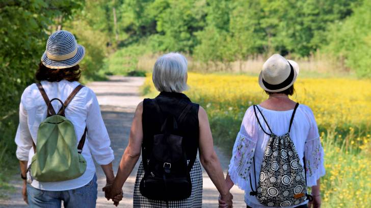 women holding hands looking hopeful