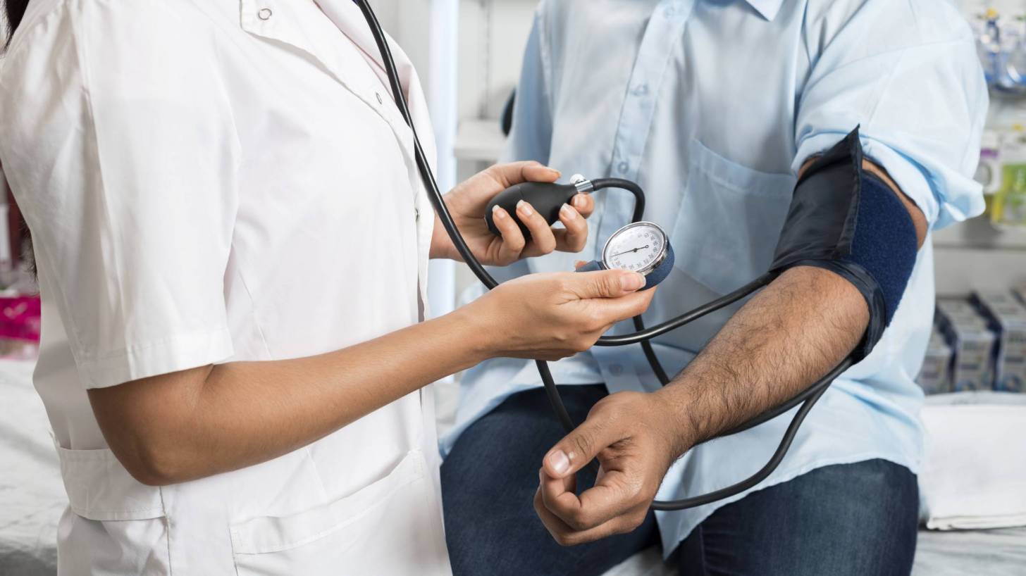 doctor taking blood pressure of patient