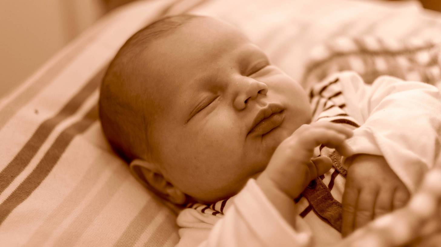 young infant sleeping in crib