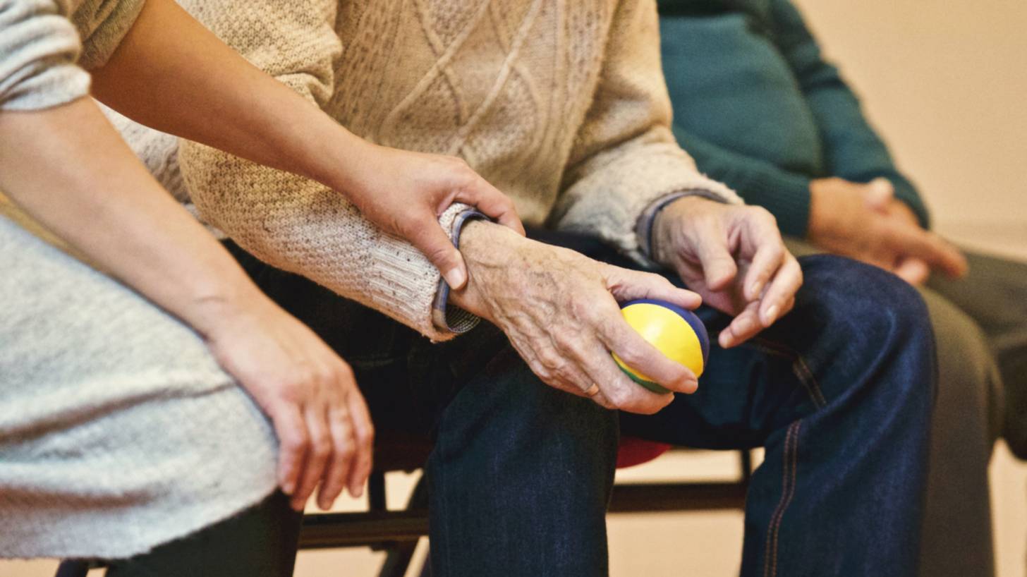 three older people sitting on a bench