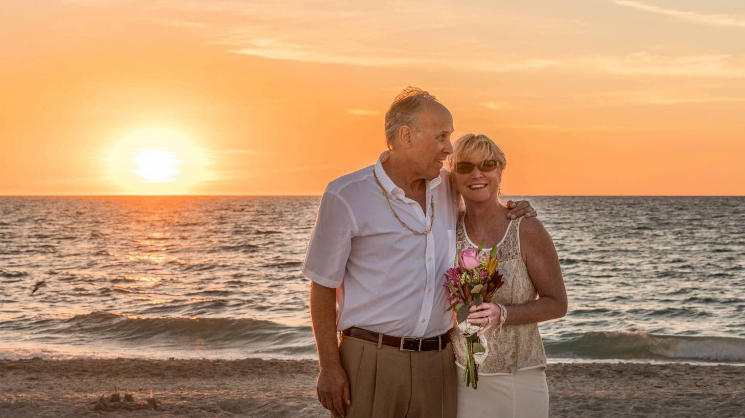 older couple on beach for wedding happy