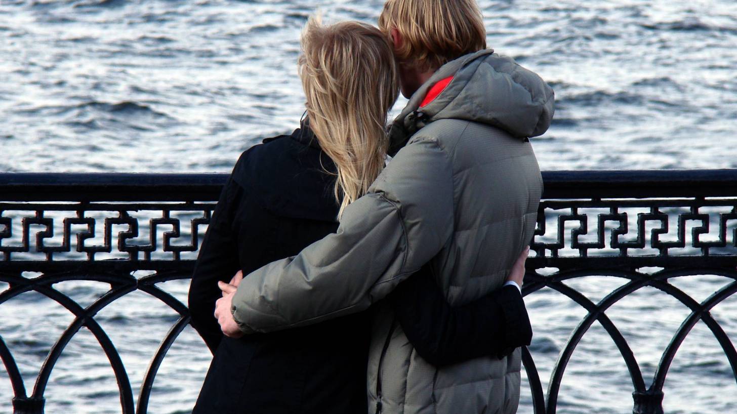 young couple hugging on a bridge