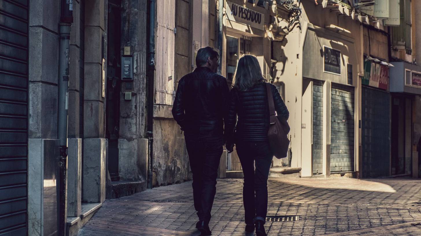 older couple walking thru an old town in europe