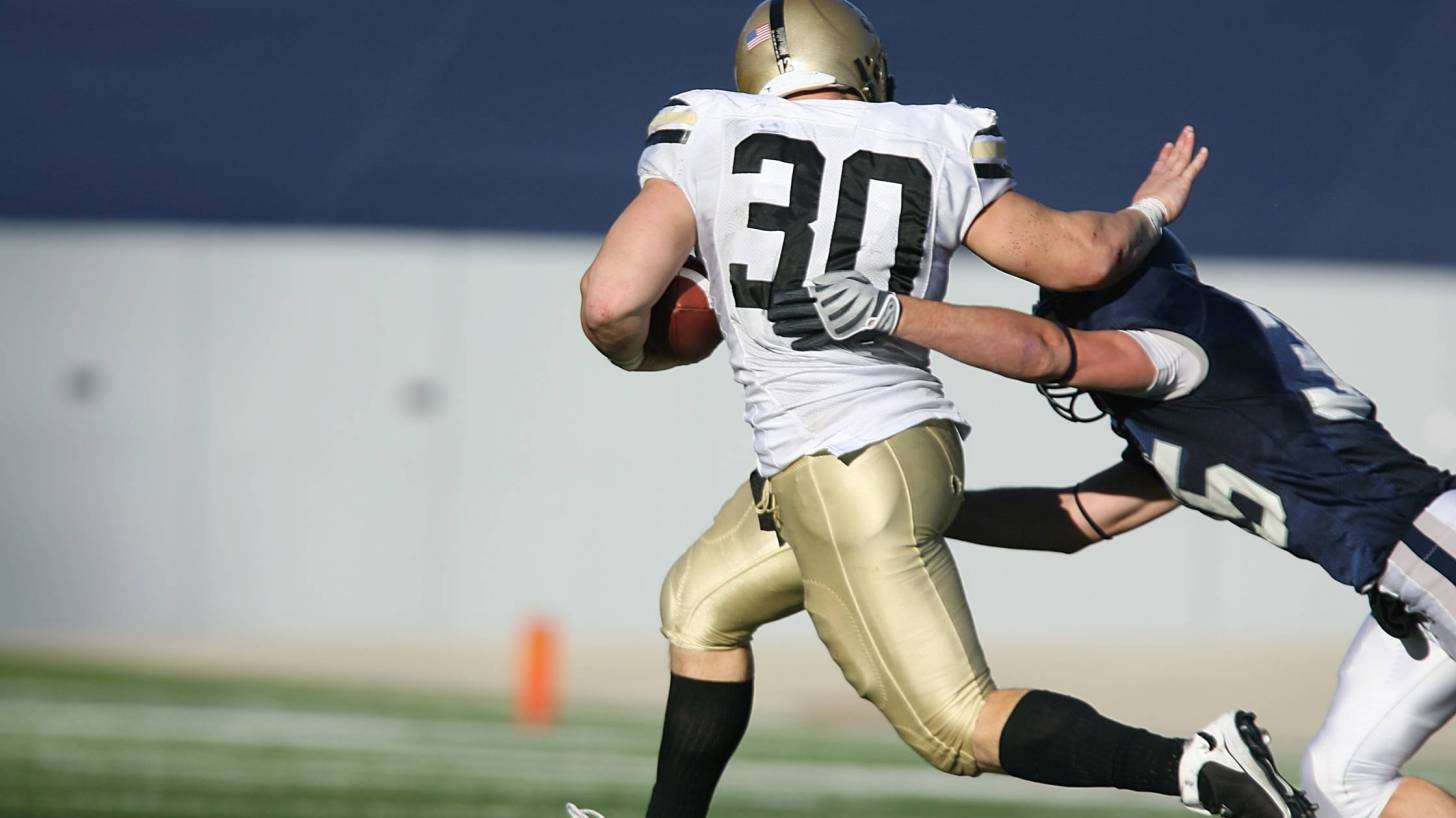 football player stiff arming another player