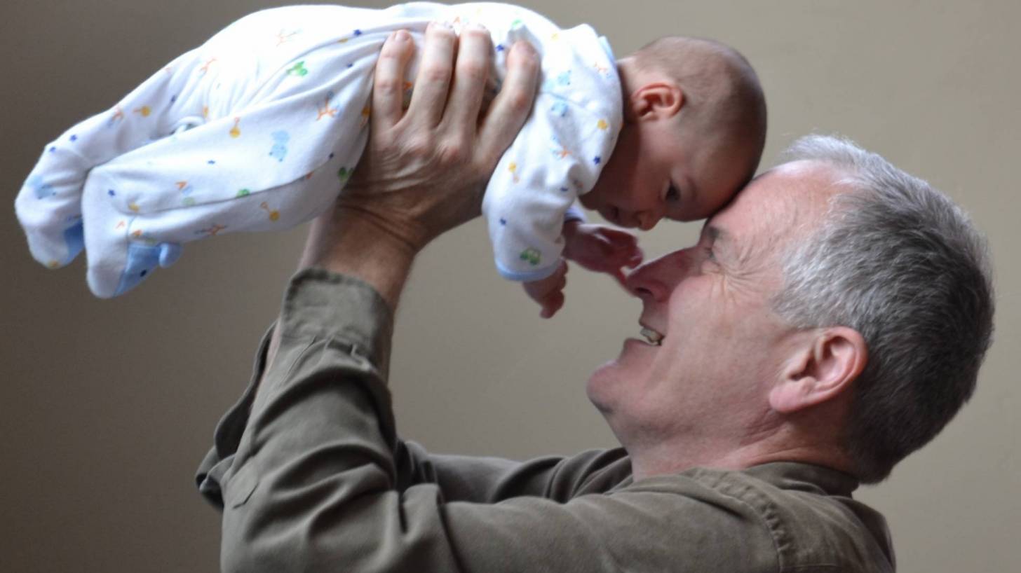 grandpa with his new grand baby protected from pertussis