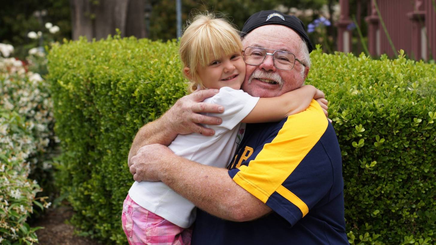 happy healthy grandpa hugging his grand daughter