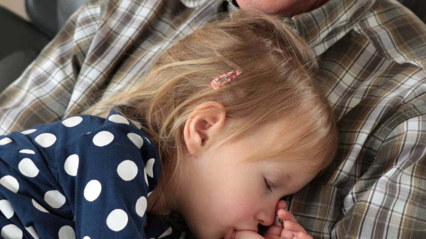 grandpa holding a sleeping grandchild