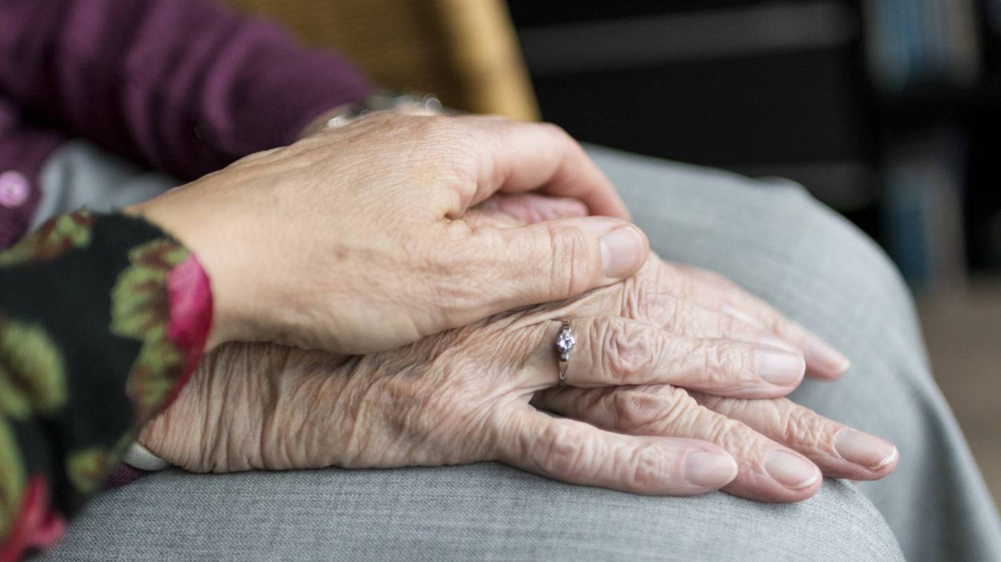 care giving holding PD patient hands