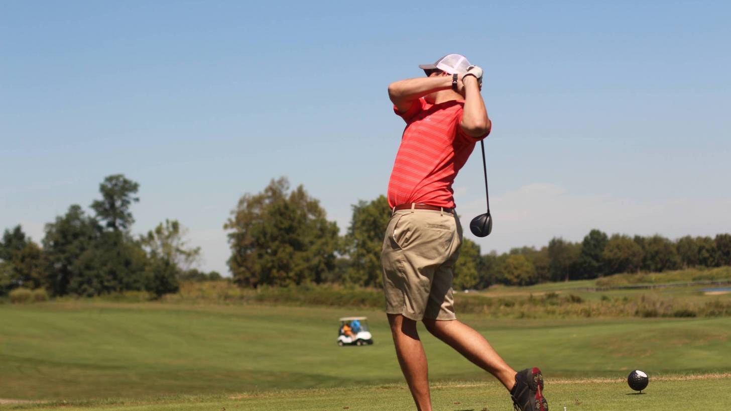 man hitting a golf ball