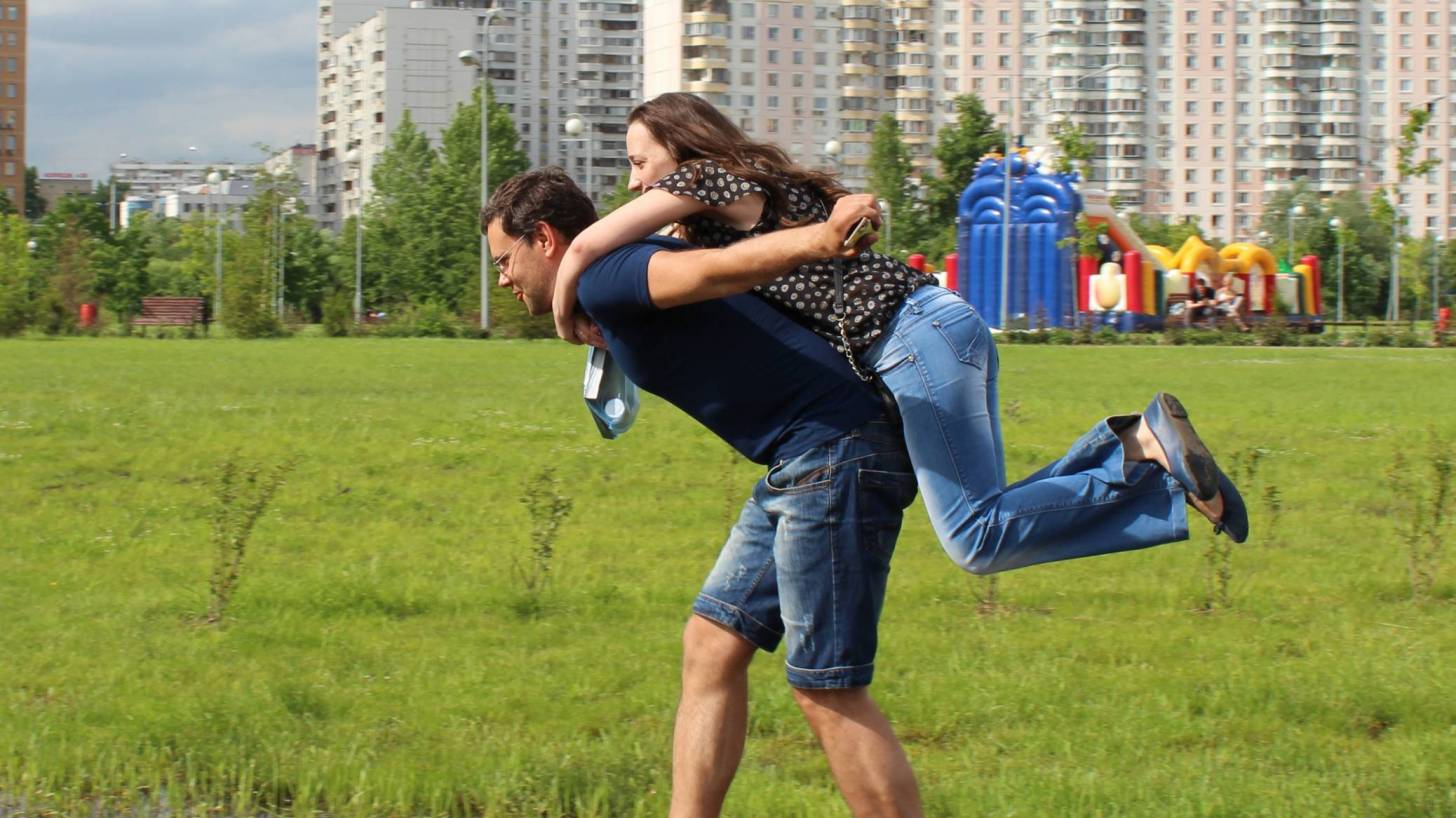 man carrying female on his back helping