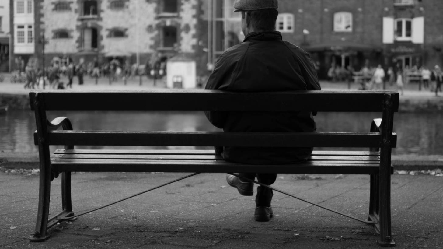 old english man sitting on a bench in the UK