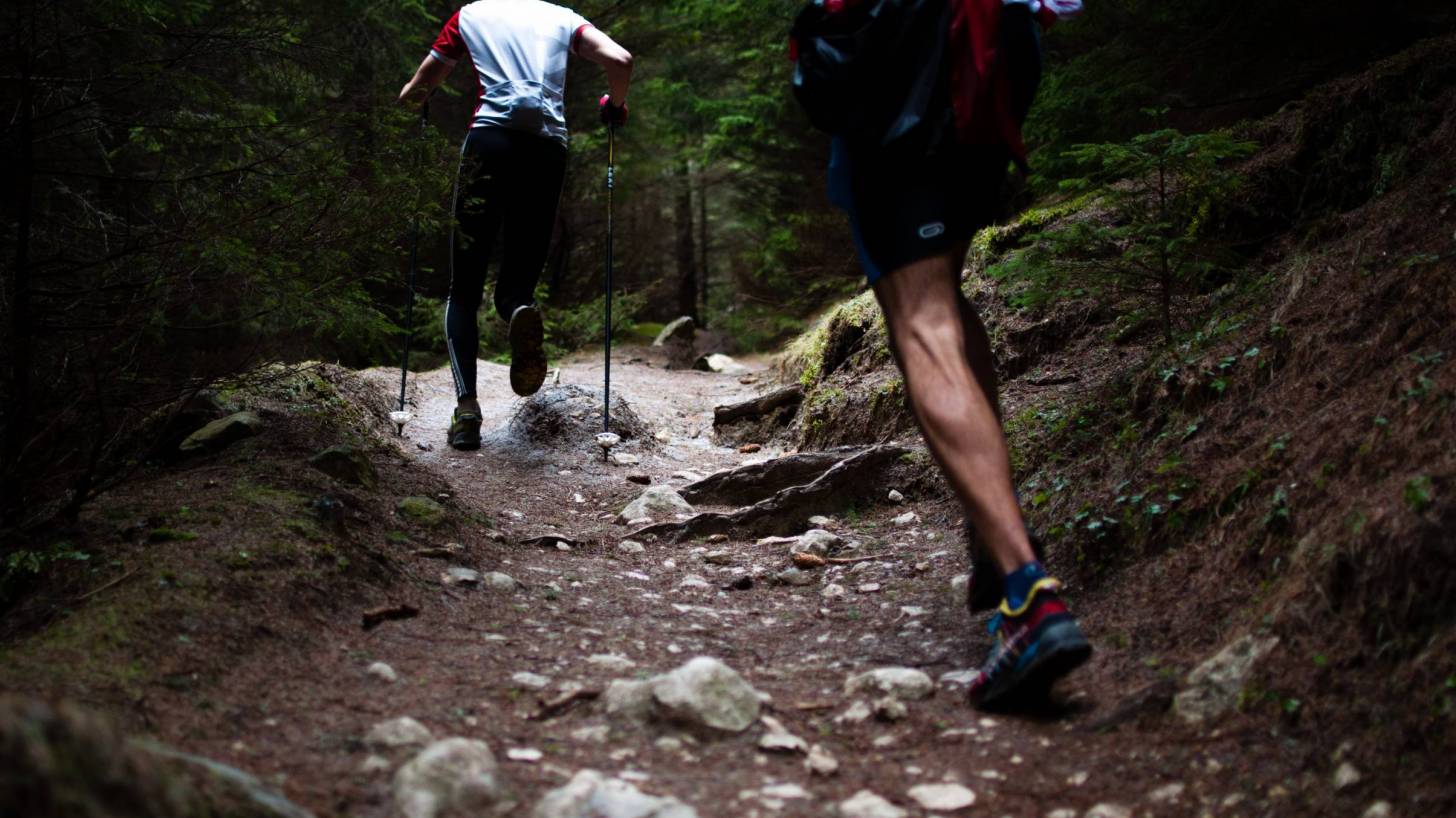 men running up a rocky hill