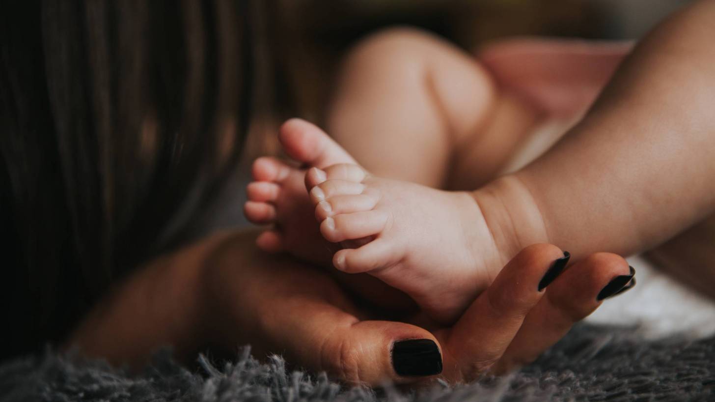 mom holding an infants feet