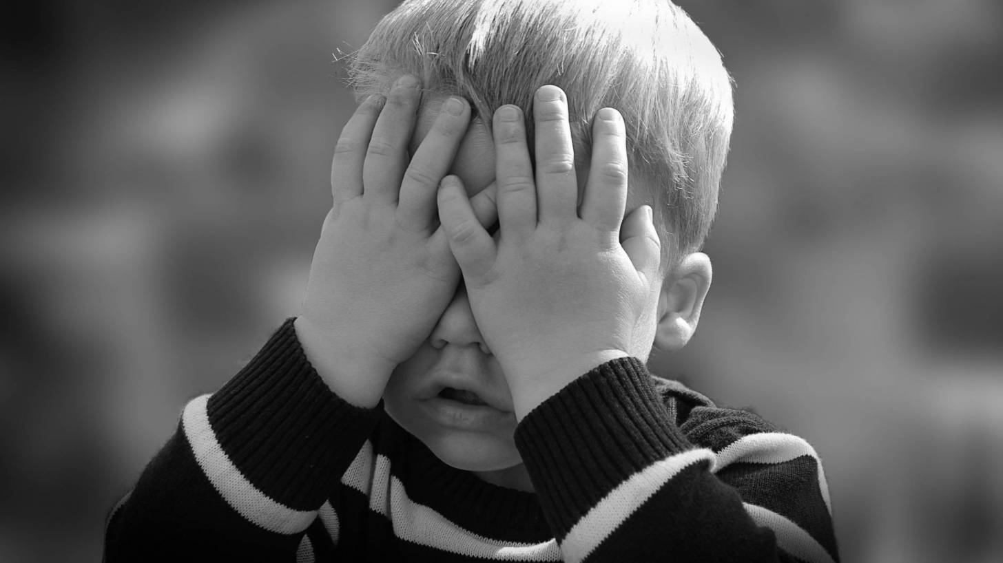 toddler covering his eyes with his hands