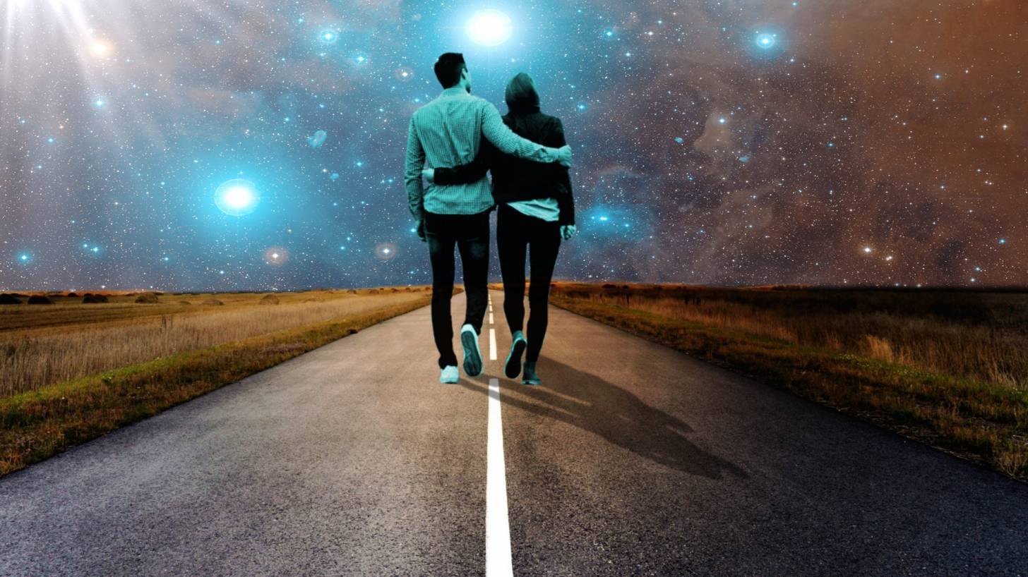 couple walking along a road in the starry night