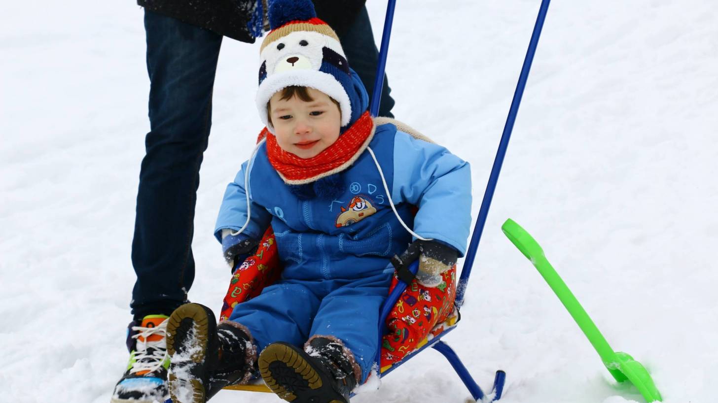 little boy on a sled in the snow