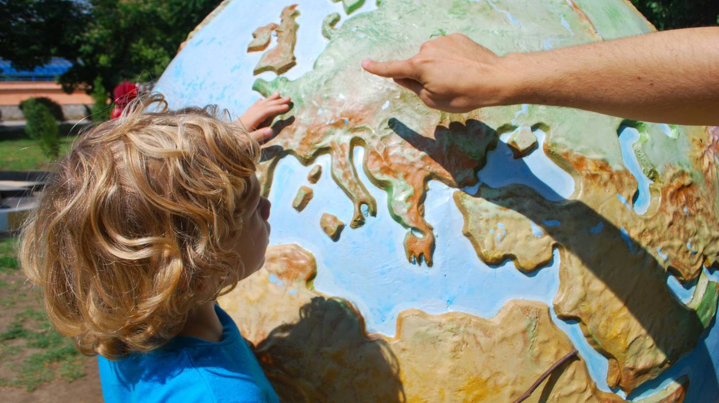 child looking at a globe