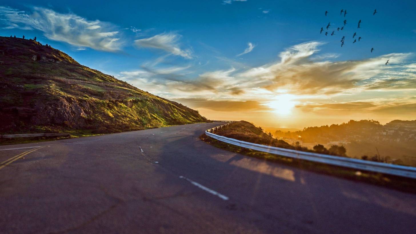 winding road with the hot sun setting on a summer night