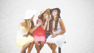 women sitting on a bench happy