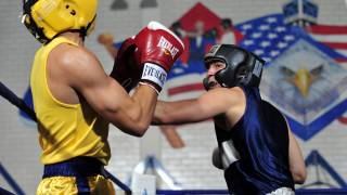 men boxing/fighting in a ring