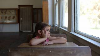 young girl in school looking out the window