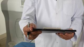 doctor with a clip board checking on a patient