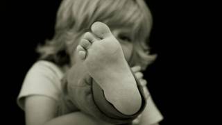 young boy holding up his foot