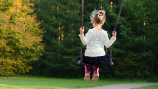 girl swinging in the back yard