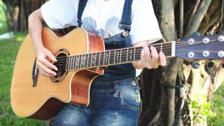 coed playing a guitar on campus