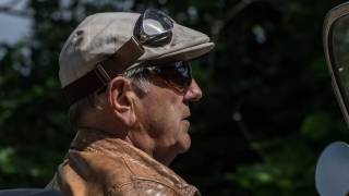 older man driving a car