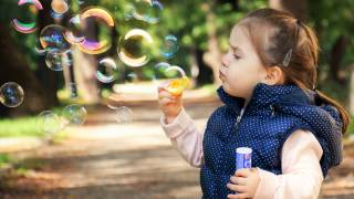 little girl blowing bubbles