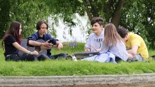 group of teens sitting in a circle outside