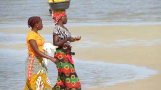 african women walknig carrying food on their head in baskets