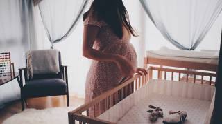 pregnant mom looking at crib