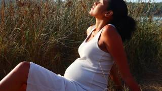 pregnant woman on the beach enjoying the sun