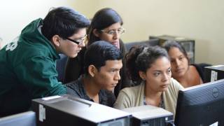 college students working closely on a computer